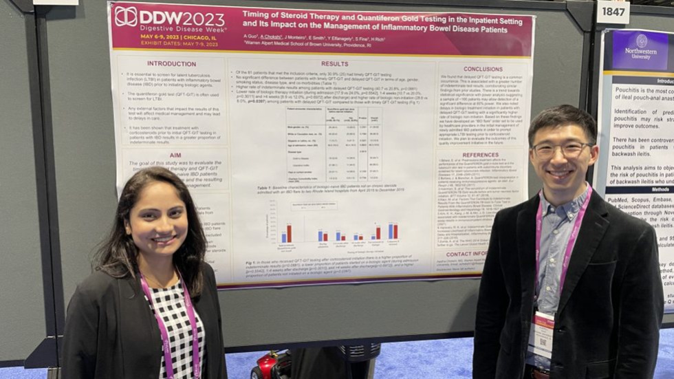 two people standing next to a poster